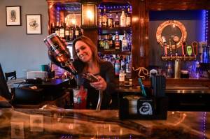 Megan Collins, co-owner of Kraken's Cove in Oak Harbor, pours a drink at the bar.  (Photo by Sam Fletcher)
