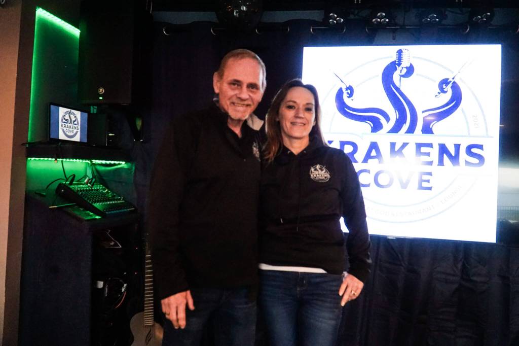 Co-owners Kevin (left) and Megan Collins (right) pose on the Kraken's Cove stage in Oak Harbor.  (Photo by Sam Fletcher)