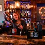 Megan Collins, co-owner of Kraken's Cove in Oak Harbor, pours a drink at the bar.  (Photo by Sam Fletcher)