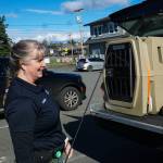Whidbey Island animal control officer Tammy Esparza displays a kennel from the back of the animal control pick-up. (Photo by Sam Fletcher)