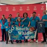Photo provided
The South Whidbey Wind celebrates their win. Back row, from left: Julietta Cedars, Stacie Lanniers, Gregg Daily, Nicky Whitehouse, Ryan James and Coach Steve Thompson, who holds the jersey for Mark Welch, a former teammate. Front row, from left: Zoe Thompson and Maddy Acken.