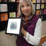 Artist Karen Rothboeck holds up a piece of her art that she framed. (Photo by David Welton)