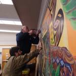 Faculties worker Tom Wade (above) and artist Nick Mann (below) install Song of the Salish Sea in council chambers. (Photo by Sam Fletcher)