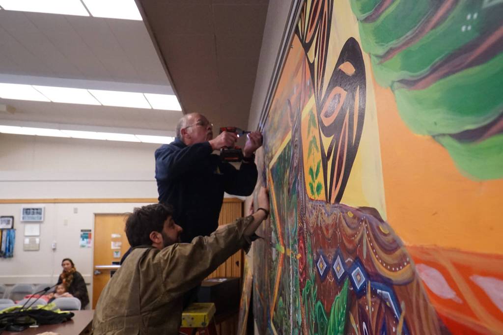 Faculties worker Tom Wade (above) and artist Nick Mann (below) install Song of the Salish Sea in council chambers. (Photo by Sam Fletcher)