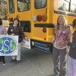 United Student Leaders members Carter McKnight, Naomi Atwood, Audrey Gmerek and Desiree Andrews pose with the new electric school bus they advocated for. (Photo provided)