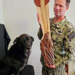 Chad Pilkington and his dog, Bane, pose with a wolf sculpture. Pilkington, 51, worked for 20 years as a corpsman biomed repair technician for the navy, repairing hospital equipment. He moved to Whidbey in 2018, and retired from the Navy in August 2023. (Photo provided)