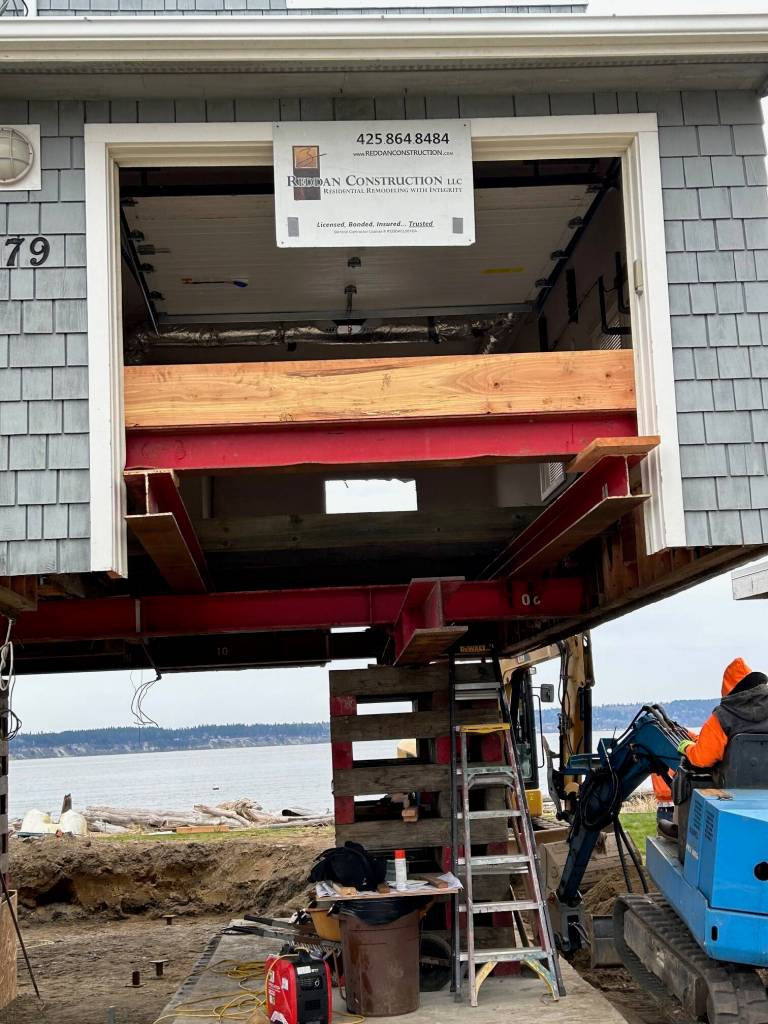 Reddan Construction workers build cribs, wooden towers, which come underneath a Whidbey Shores property. (Photo courtesy of Reddan Construction)