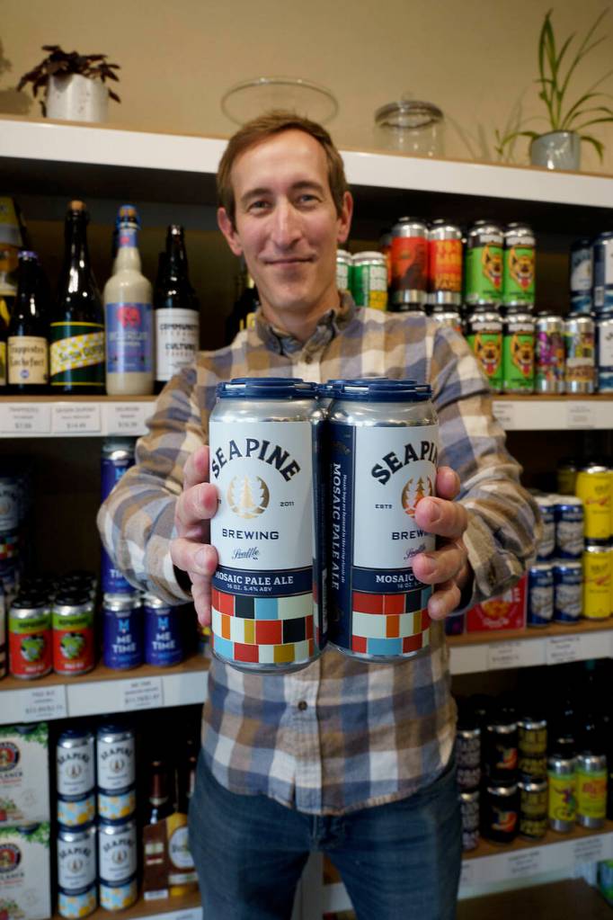 Brian Bystrom holds out his favorite beer, Mosaic Pale Ale made by Seapine Brewing Company in Seattle. (Photo by David Welton)