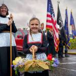 A girl dressed in traditional Dutch fashion adds color to Saturdays grey sky at the Holland Happening Parade.