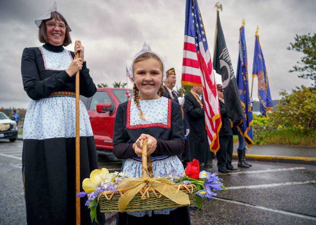 A girl dressed in traditional Dutch fashion adds color to Saturdays grey sky at the Holland Happening Parade.