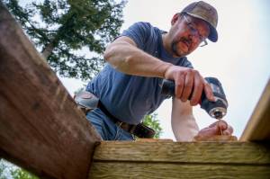 Photo by David Welton
A Hearts & Hammers volunteer repairs a deck on Saturday.