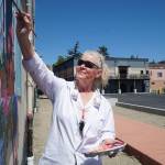 Paula Fries finishes her Serendipity Lane mural on Thursday. (Photo by Sam Fletcher)