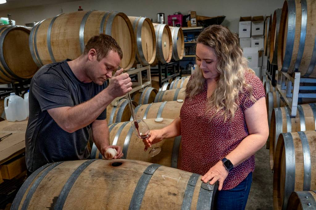 Kyle ONeill uses a pipette to transfer wine into a glass for Michelle Graham to taste. (Photo by David Welton)