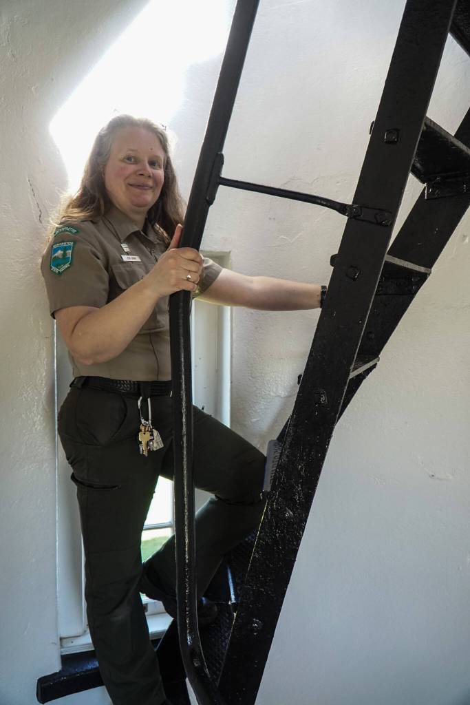 Interpretive specialist Jen Gray climbs up the ladder of the Admiralty Head Lighthouse. (Photo by Sam Fletcher)