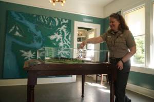 Interpretive specialist Jen Gray interacts with a Fort Casey map in the new Admiralty Head Lighthouse exhibit. (Photo by Sam Fletcher)