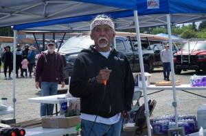 Tony Cladusbid, co-owner of the Beaver Tales Coffee franchise, announces the canoe races at the Penn Cove Water Festival on Saturday. (Photo by Sam Fletcher)