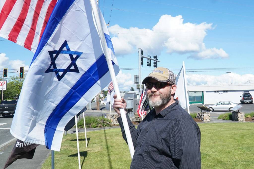 Ted Mansikka holds the Israel flag at a rally on Thursday. (Photo by Sam Fletcher)