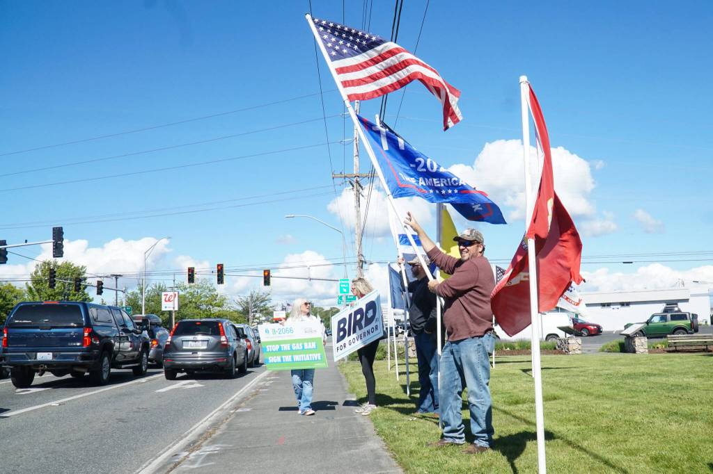 Island County Republican Party President Tim Hazelo (right) rallies with others in Oak Harbor on Thursday. (Photo by Sam Fletcher)
Island County Republican Party President Tim Hazelo (right) rallies with others in Oak Harbor on Thursday. (Photo by Sam Fletcher)