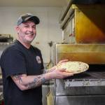 Photo by Luisa Loi
Jason Youngsman, owner of Lava Louies, is about to place a reporters pizza in a conveyor oven. Youngsmans pizza follows his fathers pizza recipe that is over 30 years old.