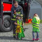 Photo by Caitlyn Anderson
Siblings Lukas and Raelynn Walker stand next to a firetruck while Lukas tries on an oxygen tank at the Touch-a-Truck event.