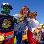 Photo by David Welton Emily Spitzer, president of Clinton Chamber of Commerce, is with the wooden statues carved by Kelly from Madrone.