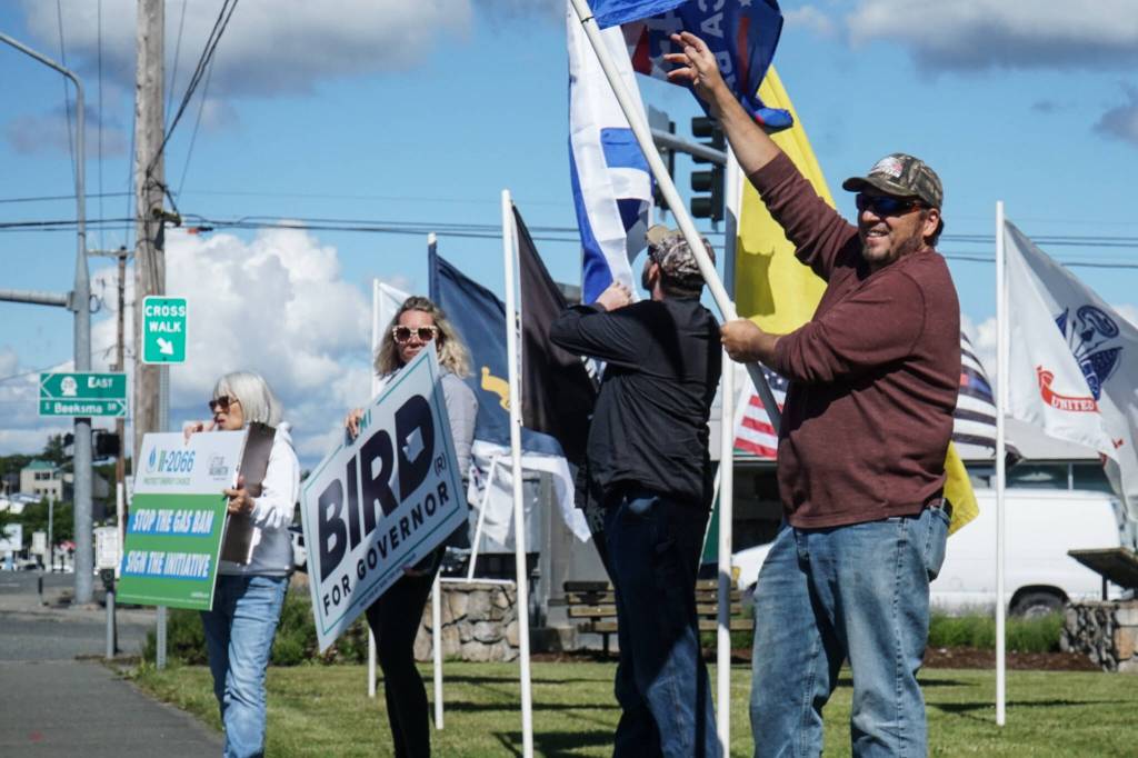 Tim Hazelo, at right, rallies for the Island County Republican Party not far from the spot where he helped save the lives of four people who overdosed. (Photo by Sam Fletcher)