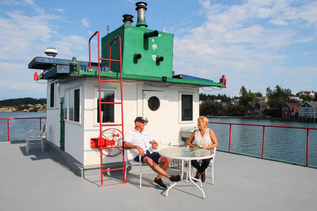 Kat and Dennis Redmon chat while enjoying the view of Penn Cove and music from a buskers performance on Front Street. (Photo by Luisa Loi)