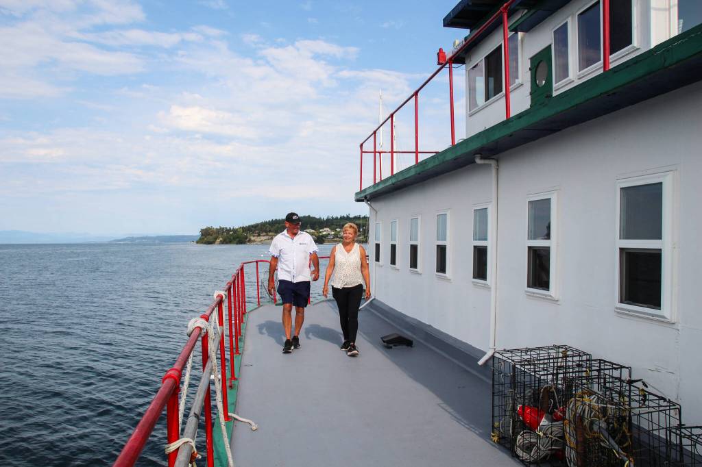Dennis and Kat Redmon walk around the ferry they transformed into a home. (Photo by Luisa Loi)