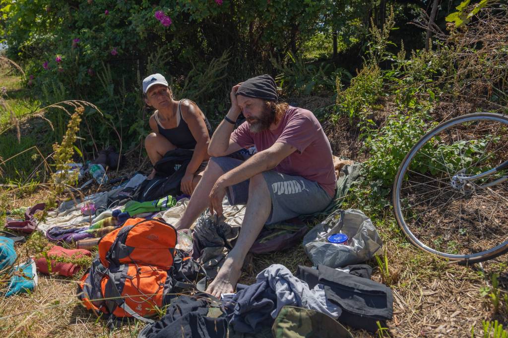 Photo by Caitlyn Anderson
Jonathan (Scooter) Fraiser and his friend repack their belongings before cleaning up and leaving the Food Forest, July 19.