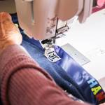 Mary Fyfe sews a ribbon to a blanket. (Photo by Luisa Loi)
