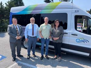 From left to right, Planning & Outreach Manager Bill Windler, Acting Director Craig Cyr, U.S. Rep. Rick Larsen and Vice Chair Jenny Bright stand before Island Transit's electric van.