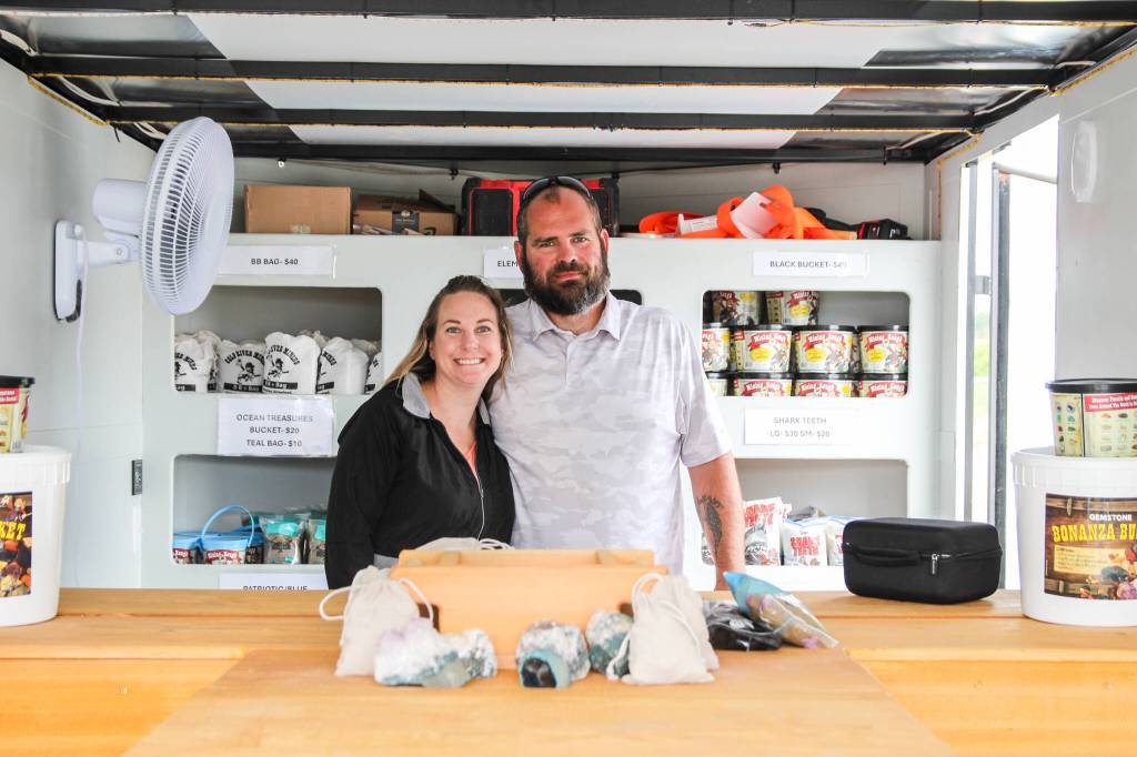 Kim and Chuck Boyer pose inside their mobile business, Whidbey Gemstone Finders, surrounded by bags of treasures. (Photo by Luisa Loi)