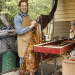 Clinton woodworker Glen Pearson with Still Standing, a burn pile rescue he found on Shaw Island. (Photo by Kira Erickson/South Whidbey Record)