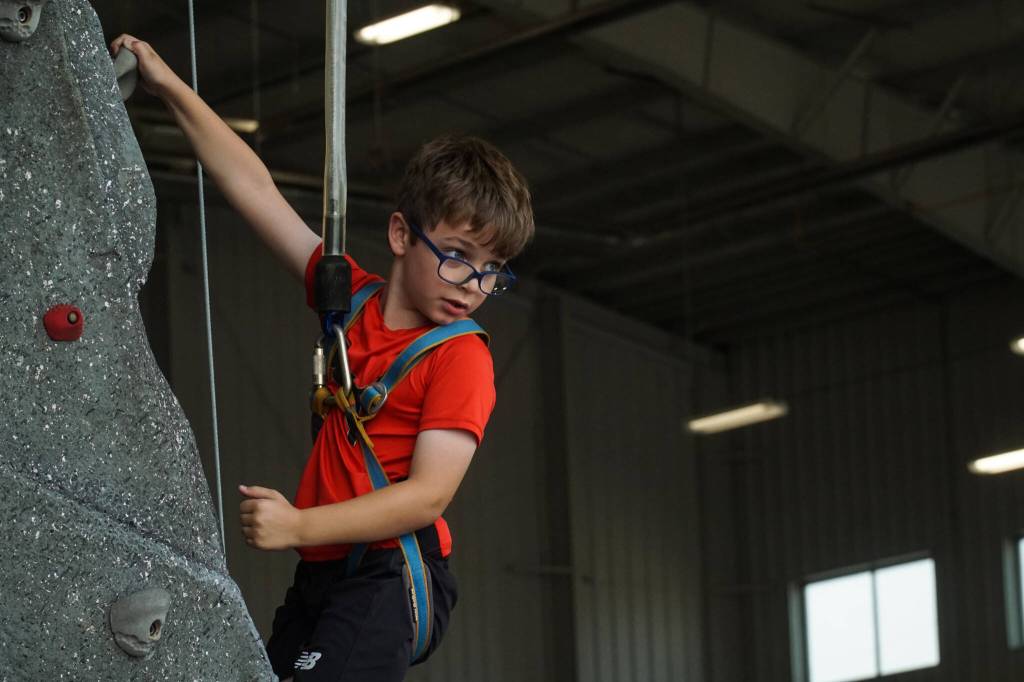 Ben Hopfinger scales the rock climbing wall at Naval Air Station Whidbey Island on Saturday. (Photo by Sam Fletcher)