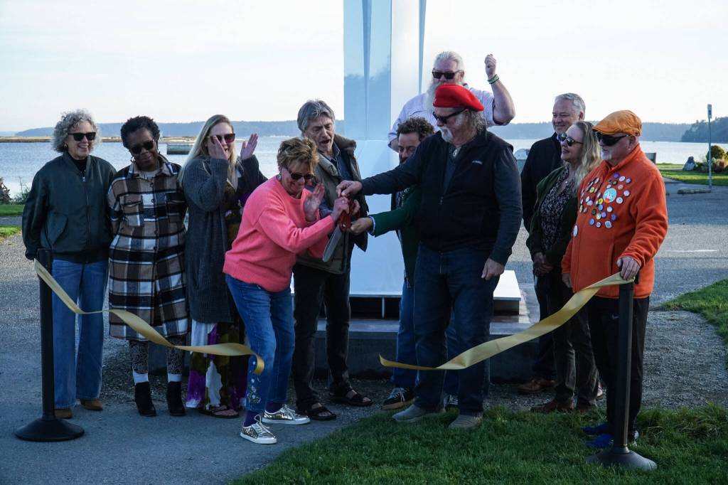 Members of the City of Oak Harbor and Sculpture Northwest cut the ribbon for the Angel de Creatividad, Oak Harbors new 40-foot sculpture at Flintstone Park on Thursday. (Photo by Sam Fletcher)