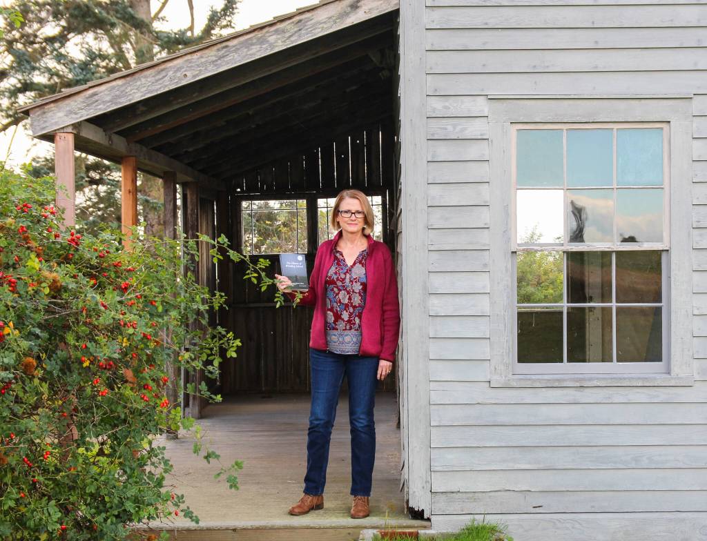 (Photo by Luisa Loi)
Victoria Shea holds The Ghosts of Whidbey Island, a project that took two years of research and writing.