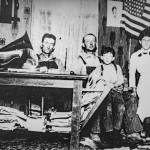 A historic Greenbank Farm photo captures the blank, emotionless faces of a family. A scrawled note says the photo includes Jim Jackson, the farms blacksmith.