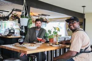 Co-Owners Sedrick Livingston, at right, and Tyler Hansen enjoy a meal at Goldie's and The Roost, a restaurant they opened with Sophia Jones.