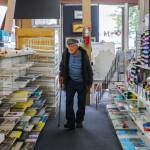 Gene Phelps, 102, walks through the aisles of his shop to check the inventory. (Photo by Luisa Loi)