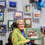 (Photo by Luisa Loi)
Kim Larsen, who owns Living Lens Photography, holds The Dragons Paw, a photo that captured a paw-shaped branch hold a water droplet. To Kim, photography is a healthy way to cope with her neurological disorder.