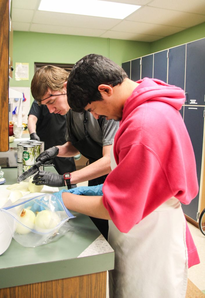 (Photo by Luisa Loi)
Devon Grau, in the foreground, cuts onions with fellow student Raiden Milliron.