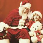 (Photo provided)
Santa leans in to hear a child as she holds Gracie the polar bear. The Greenbank Farms Santa Claus learned the art of bringing the legendary figure to life at a Santa school in Colorado.