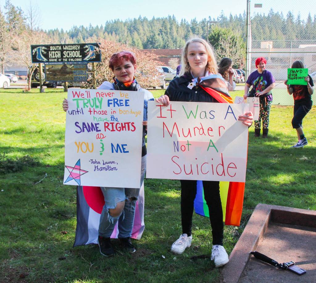 (Photo by Luisa Loi)
Aryn States, left, and Leilani Floyd pose with signs at the walkout in honor of Nex Benedict. The two South Whidbey High School students organized the protest on March 18 to demand a safer environment for LGBTQ+ people.