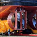 (Photo by David Welton)
A man and his dog walk by a boats turbines at the boat ramp across the street from the Nichols Brothers Boat Builders shipyard in a photo taken in 2015. This week, a barge and a catamaran will be moved to and from the shipyard.