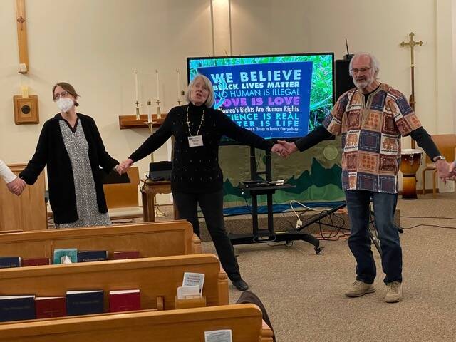 (Photo provided)
Participants of a previous Blessed are the Peacemakers event join hands and sing We Shall Overcome.