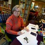 (Photo by David Welton)
Linda Beeman sorts through the stack of watercolor paintings printed in her book, A Whidbey Botanical.
