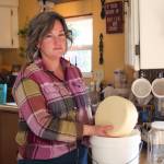 (Photo by Luisa Loi)
Diana Miller pulls out a wheel of cheese from a bucket, where it was covered in salt brine.