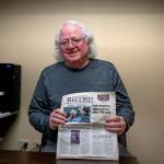 (Photo by David Welton)
Bob Herzberg holds up a 2011 copy of the <em>South Whidbey Record</em>, featuring his police chief retirement article.