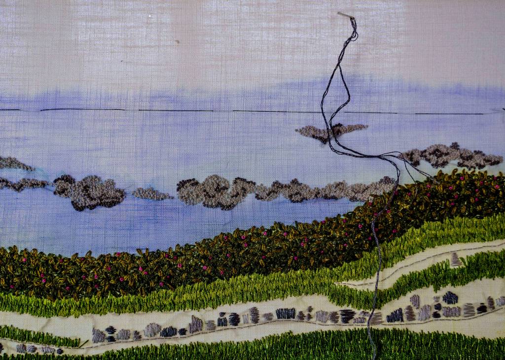 (Photo by David Welton)
Different stitches lend varied textures to the rocks, grasses, rosehips and clouds featured in this landscape.