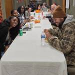 (Photo by Diane Jhueck)
Participants of a previous Pamoja Place community event gather around the table.